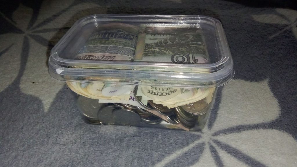 Payday Transfers Are Helping Households Rebuild Savings A piggy bank surrounded by coins representing personal savings and careful household budgeting.