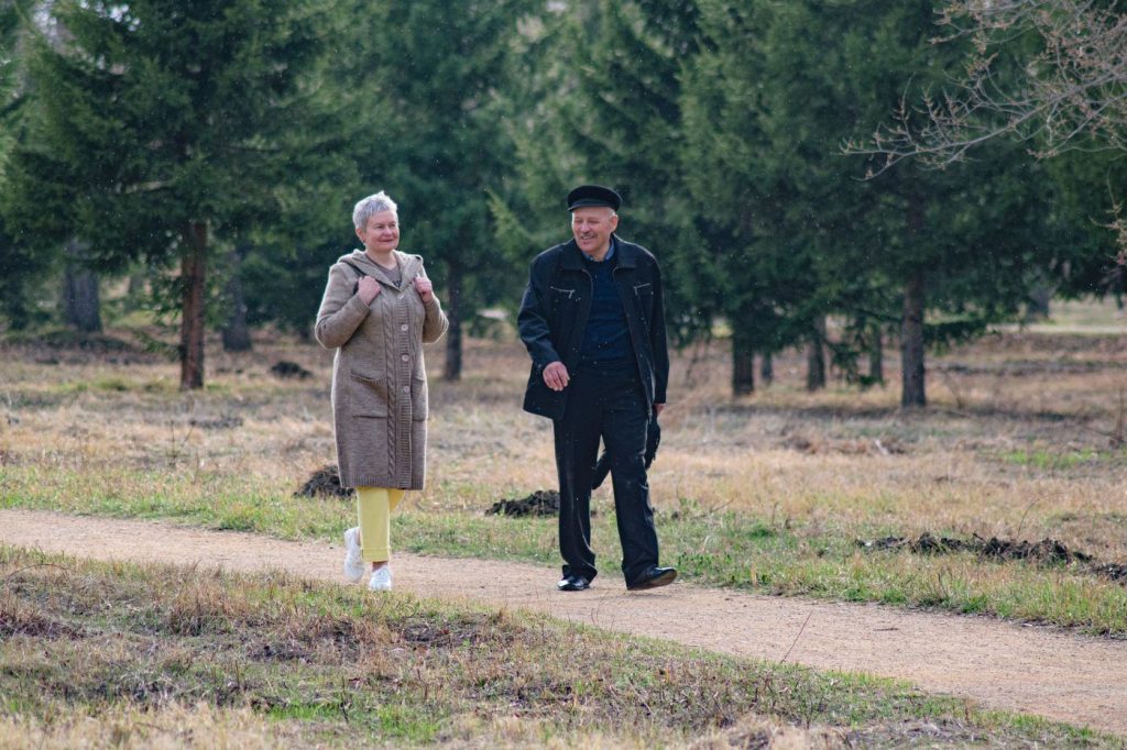 Why Walking Meetings Improve Decisions Retired couple walking together in a green park